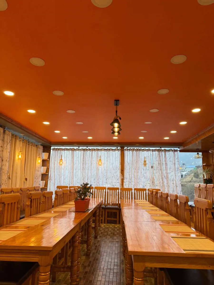 Flexible meeting and group dining space with wooden tables and large windows