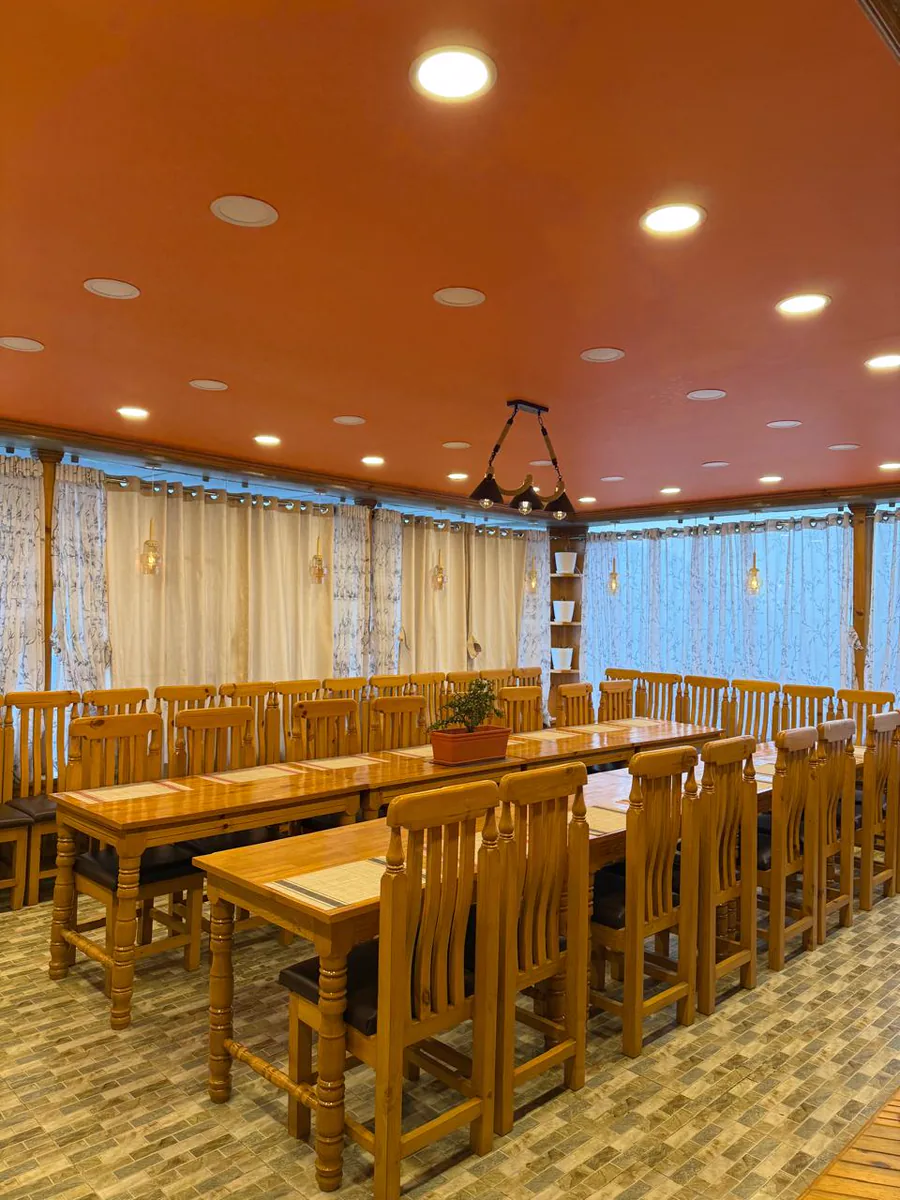 Warm group room arranged with wooden tables and chairs