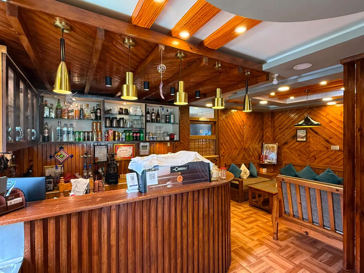 Warm wood-finished reception and café counter at The Himalayan Yak Hotel